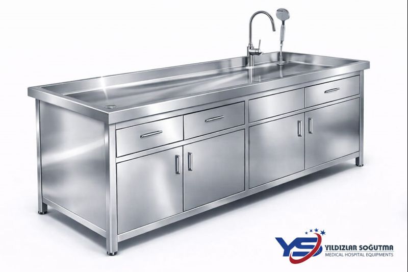 2400×900×920 mm ölçülerde, AISI 304 kalite 1,5 mm paslanmaz çelik dolaplı gasil masası. Evye, gider uyumu, dolap-çekmece depolama. Gasilhane ve morglar için profesyonel çözüm.